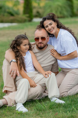 Fototapeta premium happy family is relaxing on a green lawn in the park in summer