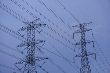 Photo of a high-voltage power transmission tower as the sun sets.