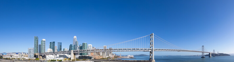 Panoramic San Francisco financial district skyline in city downtown with Oakland Bay Bridge.