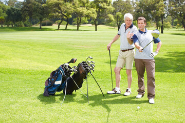 Advice, play and men on golf course together for teamwork, outdoor fun and fitness competition in nature. Sports, senior father and son on green for partnership, bonding and support in club challenge