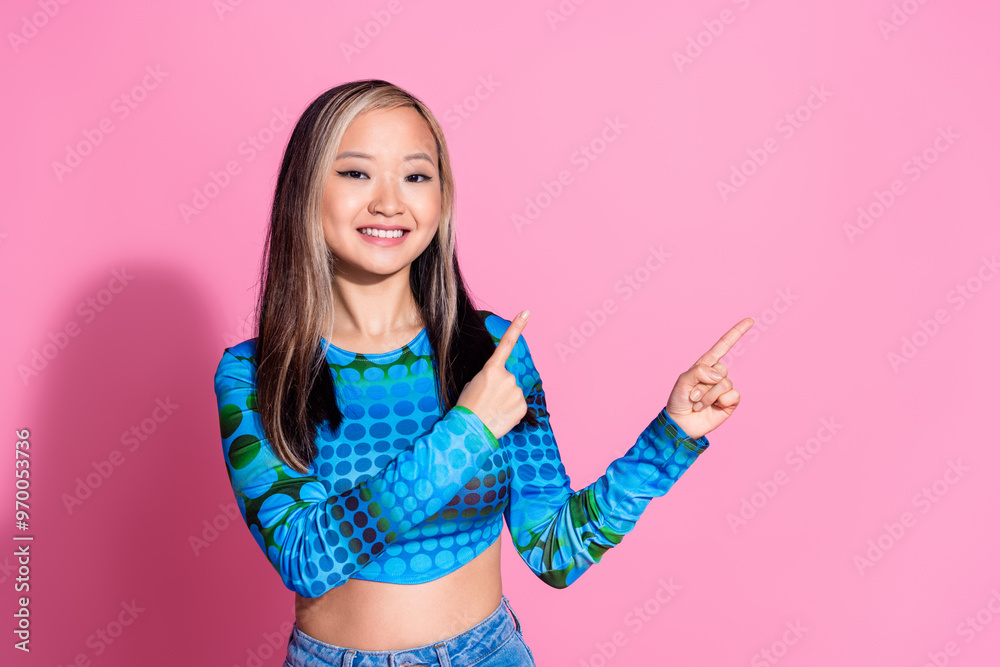 Wall mural photo of adorable lovely girl wear print top showing two fingers empty space isolated pink color bac