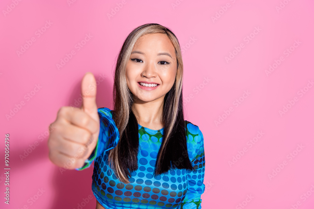 Poster photo of charming positive woman wear blue top showing you thumb up empty space isolated pink color 