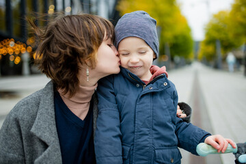 Fototapeta premium Teenage sister and her little brother having fun outdoors. Young girls with a toddler boy on autumn day.