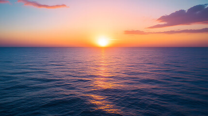 Fototapeta premium A serene sunset over a calm ocean with the sun dipping below the horizon and the sky painted in shades of orange pink and purple.