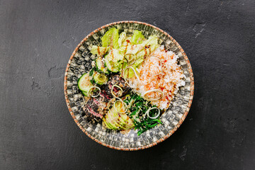 Healthy poke bowl with fresh avocado, seaweed, rice, and sesame-crusted tuna - perfect balanced meal