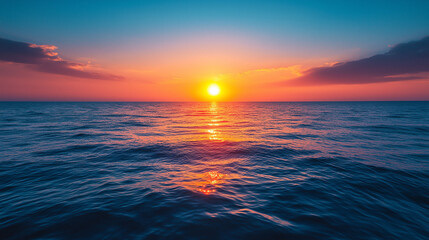 Obraz premium The sun is setting over the ocean, casting a warm glow on the water.