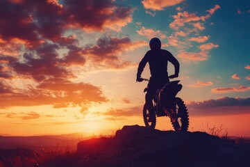 Obraz premium Silhouetted man on motocross bike on mountain rock at sunset enduro travel