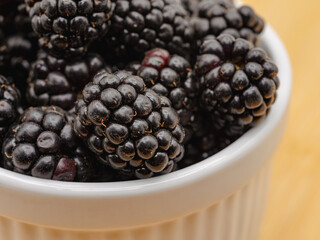 Rip blackberries in a white bowl close up 