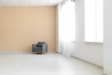 Grey armchair in stylish empty room