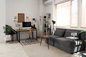 Stylish office with workplace, modern computer, sofa and photographer gadgets