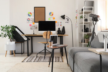 Stylish office with workplace, modern computer, sofa and photographer gadgets
