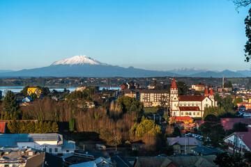 Skyline of the city of Puerto Varas on a clear and sunny winter day, with the Calbuco volcano by...