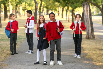 Obraz premium Group of happy pupils going to school outdoors