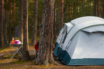 camping, a folding tent in the camp, a collapsible table and an armchair. Camping