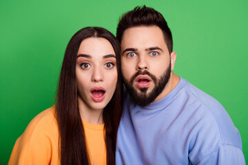 Fototapeta premium Photo of impressed confused couple wear stylish clothes open mouth isolated on green color background