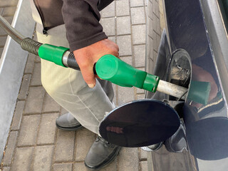 a man fills up his car at a gas station