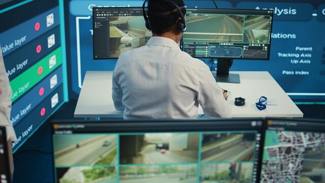 Indian call center operator giving updates about order to clients, ensuring fast delivery from observation room. Employee searching for routes without traffic on CCTV real time footage. Camera B.