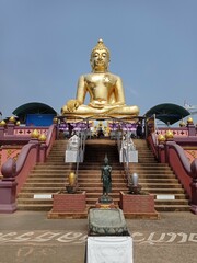 Tthe serene expression and intricate details of a golden Buddha statue in Thailand, bathed in...