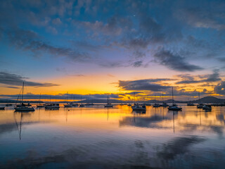 Aerial sunrise waterscape with boats, clouds and fog over the mountain range