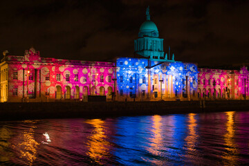 Fototapeta premium The Custom House in Dublin 1 glows beautifully during the Christmas season, with festive lights illuminating its grand neoclassical facade. 