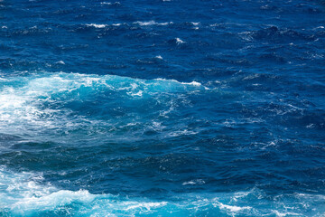 Photograph of the sea with waves and foam breaking against the shore. Concept: Holidays, lifeguard, fishing, maritime.