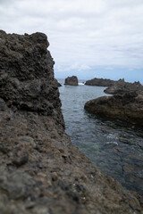 Photograph rocky beach in the sea with waves and crystal clear water. Concept: Travel, sea,...