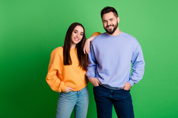 Photo of happy positive couple people wear stylish clothes isolated on green color background