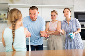 Family scene in kitchen, unpleasant conversation Parents stand face to face with daughter and scold...