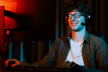 Young gaming streamer team getting winner players with Esport on pc online fighting wearing headphones in neon lighting room. Practising strategy plan to win competitors for next level. Gusher.