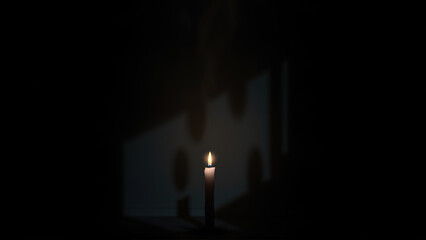 Fototapeta premium Halloween candle glowing in the darkness with shadows on the wall