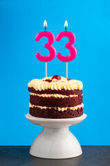 Red velvet birthday cake with number 33 candle