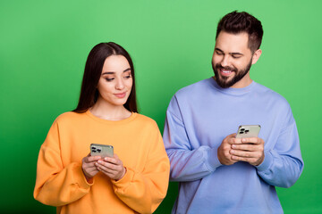 Photo of lovely pretty couple wear stylish outfit hold use modern device isolated on green color background