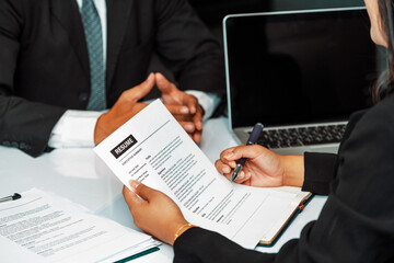 Human resources department manager reads CV resume document of an employee candidate at interview room. Job application, recruit and labor hiring concept. uds