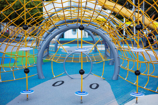 A close-up of the colorful climbing nets and play structures at Frank Kitts Park Playground in Wellington, New Zealand