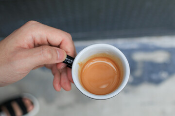 Man holding cup of hot coffee espresso. Breakfast beverage morning concept. Light atmosphere, on dark background, with copy space.