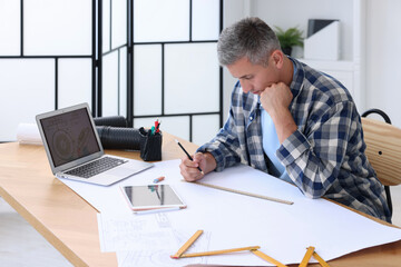 Fototapeta premium Architect making engineering drawing at wooden table in office
