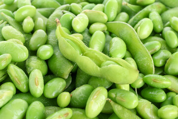 Raw green edamame soybeans and pods as background, closeup