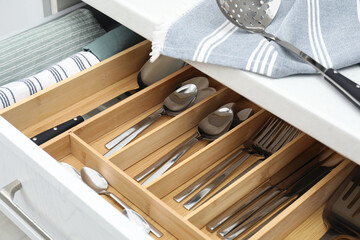 Box with cutlery in drawer, closeup. Kitchen utensils storage