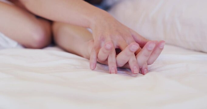 Couple, hand holding and love in bed closeup for happy partnership, romance or marriage celebration. People, fingers and intimate dating for waking up in morning or connection, relax peace or calm