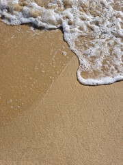 
It is a sandy beach with waves rolling in.