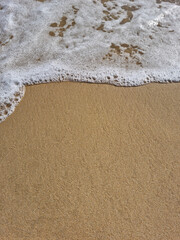 
It is a sandy beach with waves rolling in.