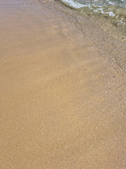 
It is a sandy beach with waves rolling in.