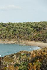 Coastline view over rocks to a golden sand private beach