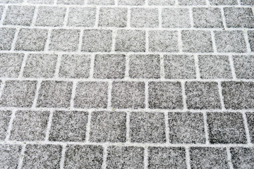 square paving stone with snow on it