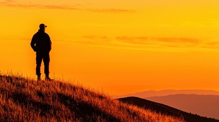 Silhouette of Man on Hilltop at Sunset