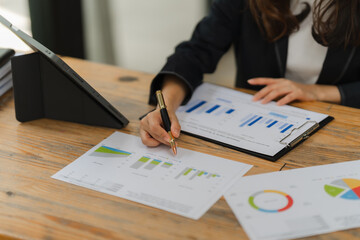 Businesswoman Analyzing Data: A close-up shot of a businesswoman meticulously examining a...