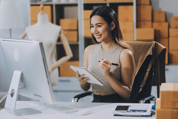 Obraz premium Successful Woman start up online seller at workplace. small business entrepreneur SME or freelance asian woman working with box at home.