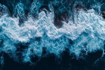 Fototapeta premium A breathtaking aerial view of towering sea cliffs along a rugged coastline with waves crashing against the rocky shore, highlighted by a dramatic interplay of sunlight and shadow