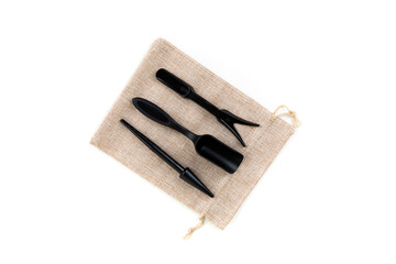 Small planting tools on a canvas cinch bag isolated over white