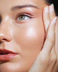 Close-Up of Woman Touching Face With Radiant Skin and Green Eye